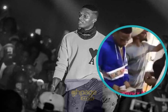 Wizkid gives out dollars to fans at a barbering saloon