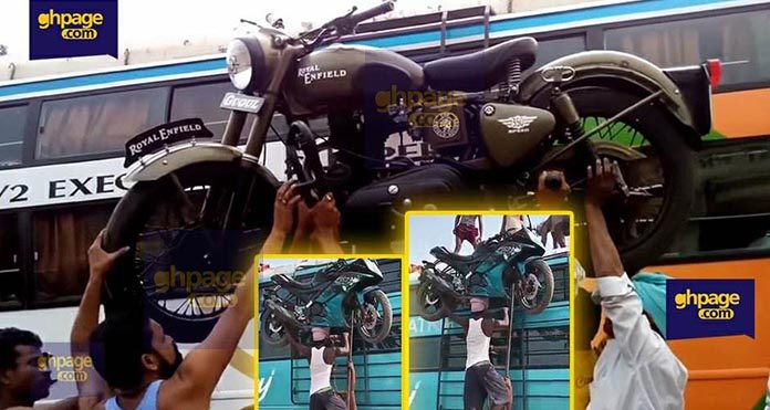 Video: Ghanaian man abroad carries big motorbike on his head as he climbs a ladder