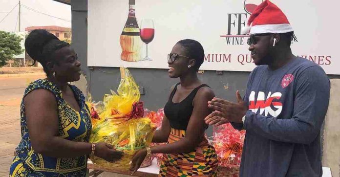 Fella Makafui presenting a gift to a widow on Christmas eve 