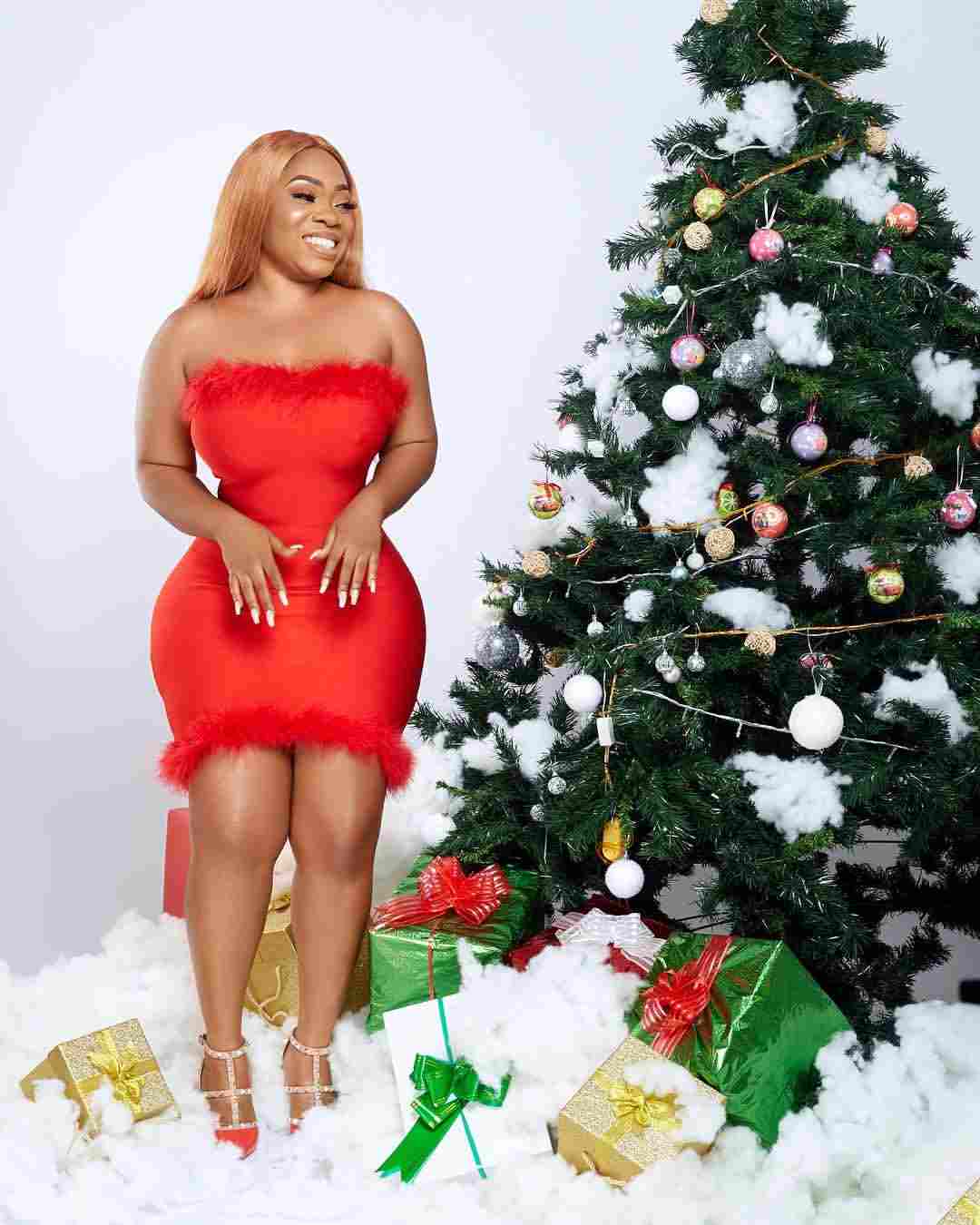 Actress Moesha posing with a Christmas tree