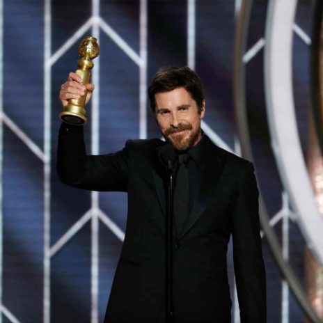 Christian Bale holding his Golden globes award