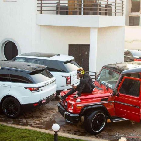 Shatta Wale posing with his cars 