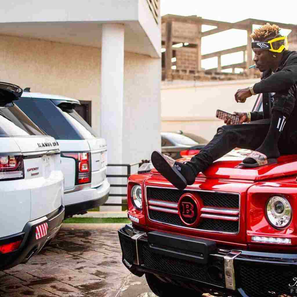 Shatta Wale posing with his cars in his house