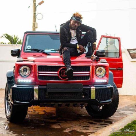 Shatta Wale posing with his latest cars 