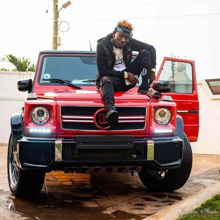 Shatta Wale posing with his latest cars