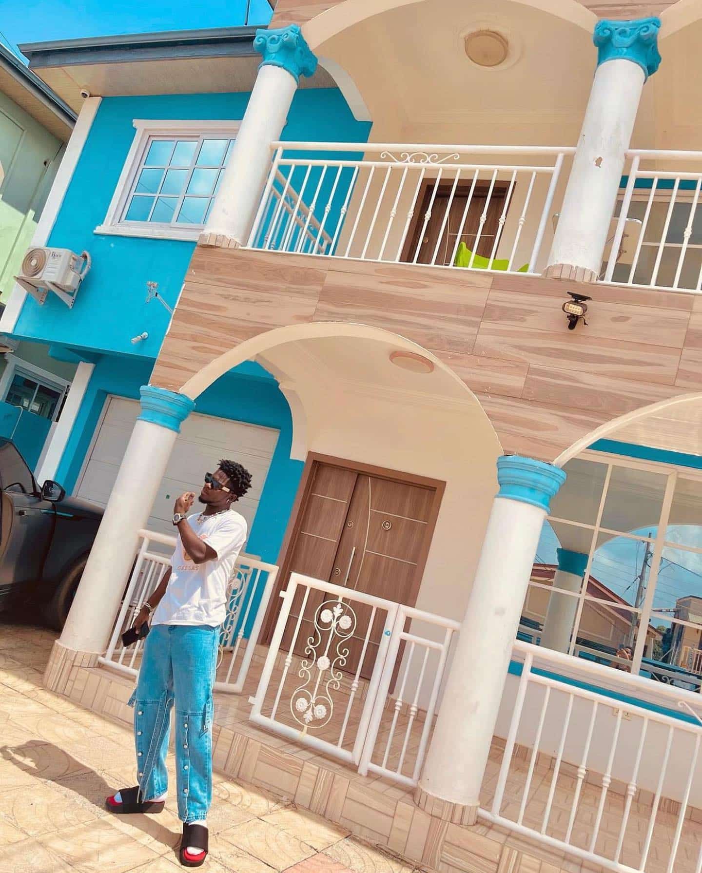Kuami Eugene drops new stunning pictures in front of a heavy mansion